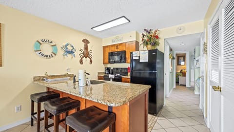 Royal Palms 406 - Spacious kitchen with a fully equipped setup and island seating for three.