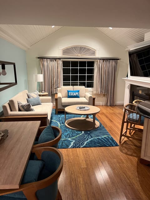 View from the foyer to the living room with couch, fireplace & large-screen TV.