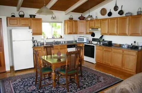 Another view of the fully stocked kitchen. Antique table with leaves sits 8