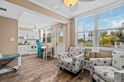 Fully equipped kitchen with fridge, oven, stove, microwave, and Keurig coffee maker, flowing into a cozy living and dining space.