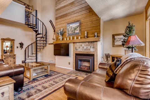 Living room with spiral staircase to loft and master bedroom
