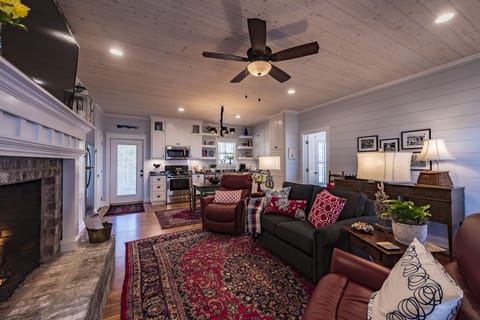 A large-screen HDTV is above the fireplace, with additional TVs in each bedroom.