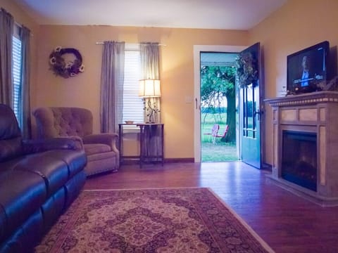 Living Room With TV, Electric Fireplace, And Double Recliners in Leather Sofa.