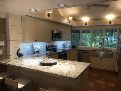 Kitchen with 3 counter height chairs at the peninsula. 