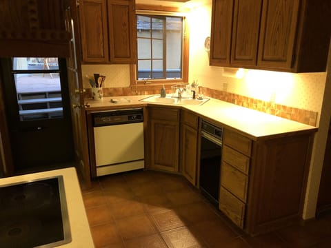 A corner sink window provides natural light, cool breezes, and a back deck view.