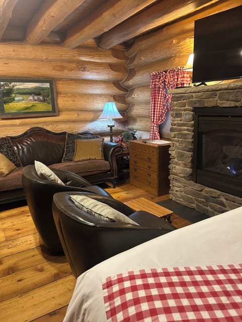 Queen bed, leather barrel chairs and leather couch with gas fireplace
