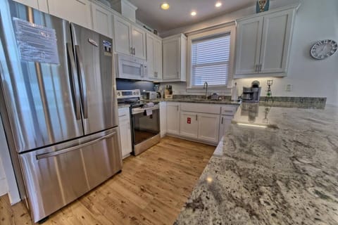 Sleek stainless steel appliances and granite countertops elevate this bright kitchen.