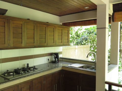 The kitchen with stainless cooktop & sink. Microwave and fridge are out of view.