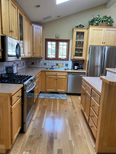 The kitchen is well stocked with new stainless appliances & a 5 burner gas stove