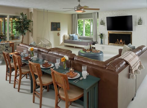 Living room features gas fireplace, streaming tv, daybeds, and views of river.