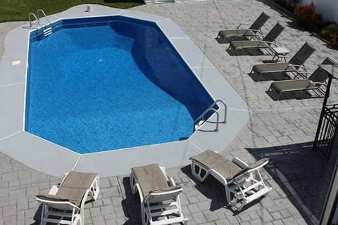 View from sliding glass doors of kitchen-portion of backyard pool area.