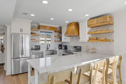 Cook memorable meals in this bright, fully equipped kitchen featuring gleaming appliances, spacious countertops, and warm wood accents that make every culinary creation feel special.