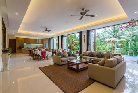 A spacious Living area with set of sofa,  Dinning tables and kitchen 