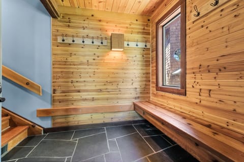 Warm wood walls and built-in benches welcome you in this cozy mudroom, where hooks and storage keep your gear organized after a day exploring the mountains.