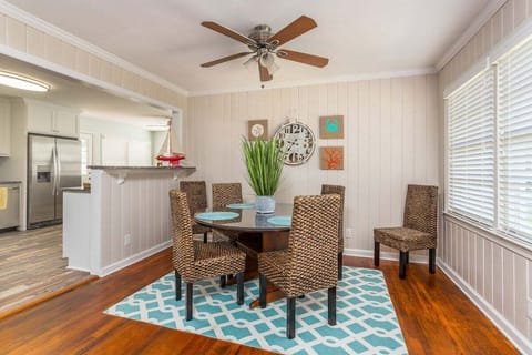Dining area with wicker chairs, teal rug, and ceiling fan