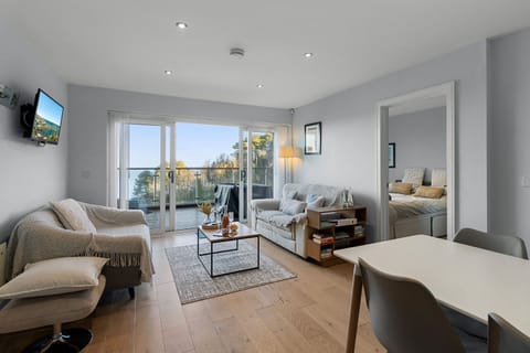 Light and contemporary living area with full width sliding doors opening onto the large balcony.