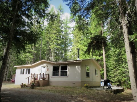 Front of house nestled in the woods.
