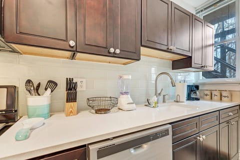 Glass tile surrounds this custom kitchen with a pull down faucet.
