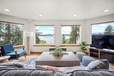 Unwind in your bright living room where floor-to-ceiling windows frame stunning lake views, creating the perfect backdrop for relaxation.