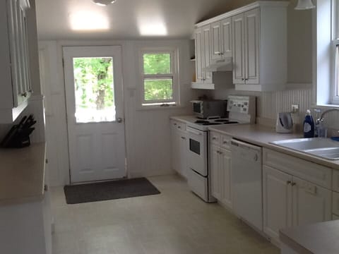 The back door of the kitchen leads to the set of stairs going down to the lower entrance deck and the parking area below.