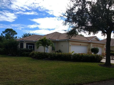 Front of villa with attached car and a 1/4 (golf car) garage