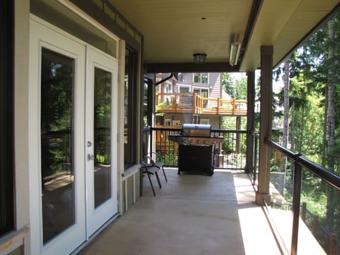 The enclosed deck on the main level with BBQ and outdoor eating area.