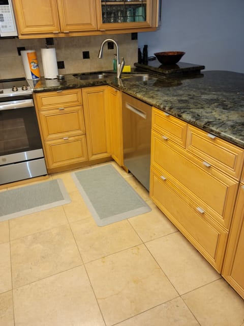 The kitchen showing sink, dishwasher, oven, and breakfast counter top.