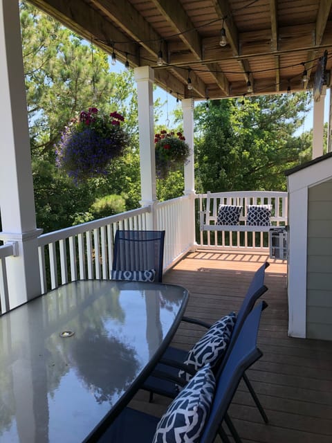 Main floor deck with string lights, porch swing, outdoor dining set. 