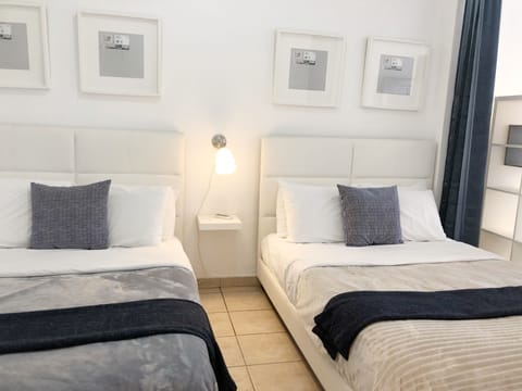 Dormitorio con dos camas Queen en el que caben 2 personas en cada una, tiene AC.