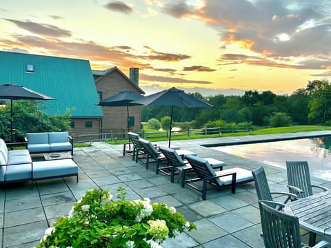 Pool area with multiple seating areas and additional charcoal grill 