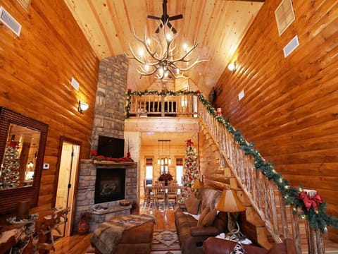Gather around the stone fireplace in this inviting, open-concept cabin where rustic comfort meets festive holiday warmth.