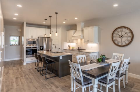 Dining Table & Kitchen - The Kitchen and Dining Table can accommodate 9 adults and is stocked with pots, pans, baking sheets, mixing bowls, plates, bowls, cups, silverware, and a collection of cooking utensils.
