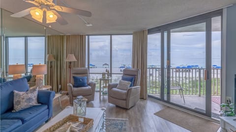 Sink into your coastal living room with panoramic ocean views, where the sea breeze flows through sliding doors to your private balcony.