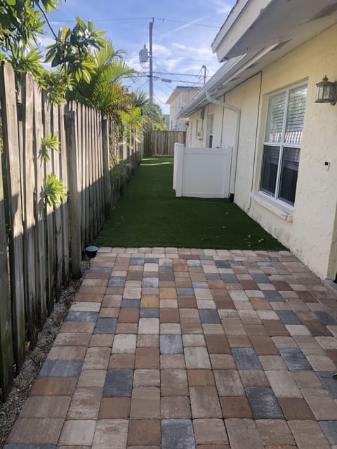 Yard on entrance. Artificial grass. Space between buildings for kids to play.
