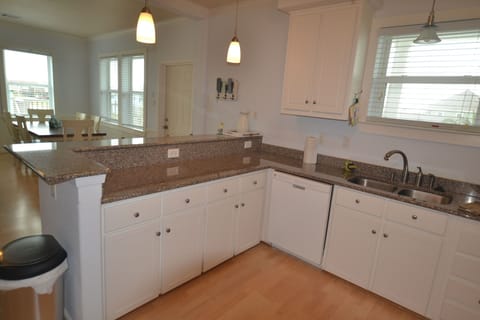 Open kitchen with snack bar with stools and granite counter tops.