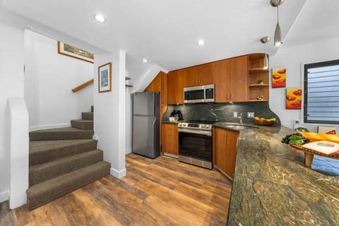 Open-concept kitchen with warm wood finishes and direct access to dining and living areas.