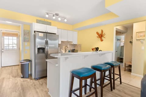 Newly renovated, open kitchen & living room with all new appliances, breakfast bar, 4-seat dining table, couch, accent chair and flat screen smart Roku TV.