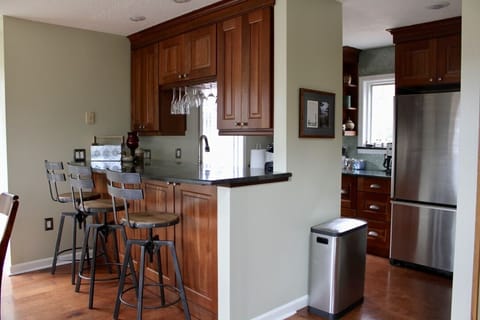 View into the kitchen, seating for 3 at the granite bar top.