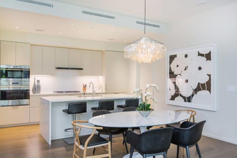 Gather around the designer dining table in this elegant open-concept layout, perfect for relaxed meals or entertaining in paradise.