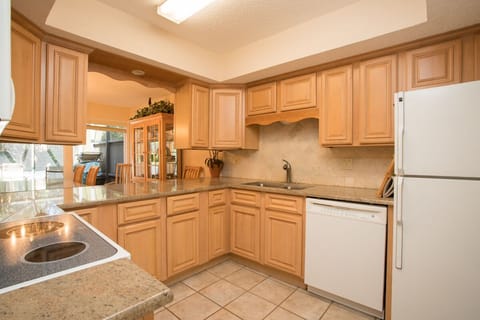 - Cook with ease in this spacious kitchen featuring wraparound counters and classic style
- Fully stocked with fridge, stove, microwave, dishwasher, and everything you need
- Pass through window opens to dining area for convenient serving