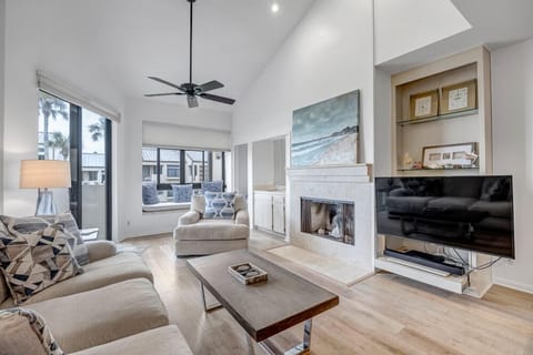 - Stylish living room with vaulted ceilings, cozy fireplace, and mounted TV
- Large windows let in natural light and offer relaxing views of the outdoors
- Plush sofas and modern décor create the perfect spot for lounging or reading