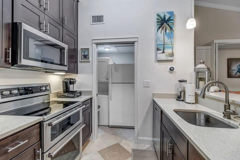 - Sleek galley style kitchen featuring full appliances, coffee station, and bright decor
- Wide sink, under cabinet lighting, and artful coastal touches make prep time a joy
- Everything you need to cook, snack, or sip in a well appointed space