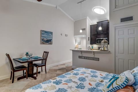 - Full view of living, dining, and kitchen areas with coastal art and neutral tones
- Compact table for two pairs perfectly with island bar for multiple dining spots
- Elevated ceilings and clever layout make this studio style setup feel surprisingly spacious