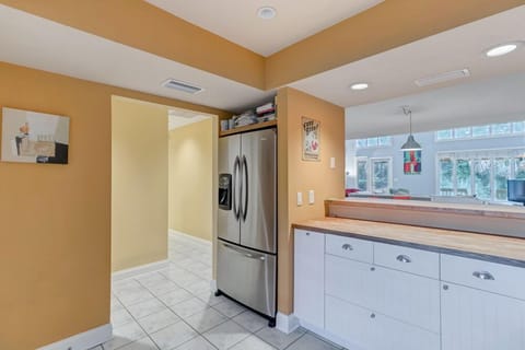 - Corner view of the kitchen highlights a sleek stainless fridge and wood trim
- Bright and airy, with open sightlines to the breakfast bar and living room
- Perfect space for storing snacks and drinks for beach days or movie nights