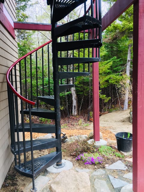 A spiral staircase leads up to the studio apartment