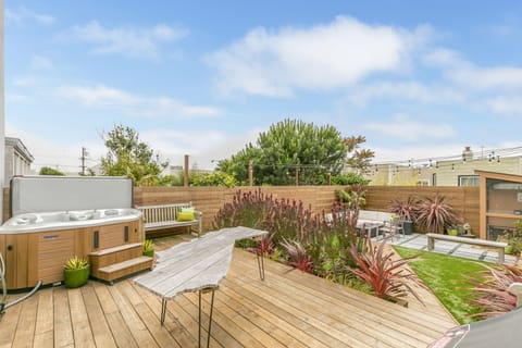 Large backyard with fire pit, hot tub, and multiple seating areas