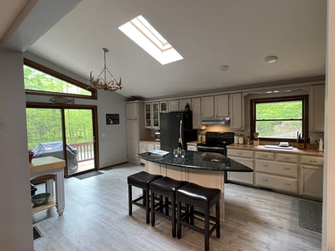 Kitchen with doorwall access to side deck and gas grill.