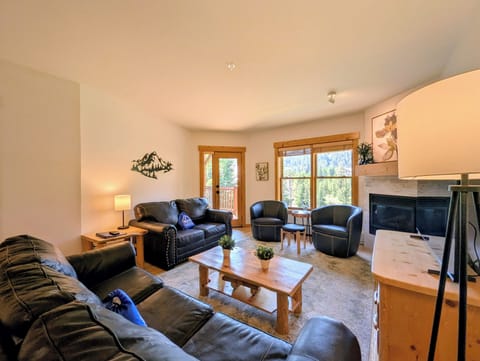 Settle into comfortable leather seating with forest views framing your stay. Natural light fills this inviting space where you can unwind by the fireplace after your mountain adventures.