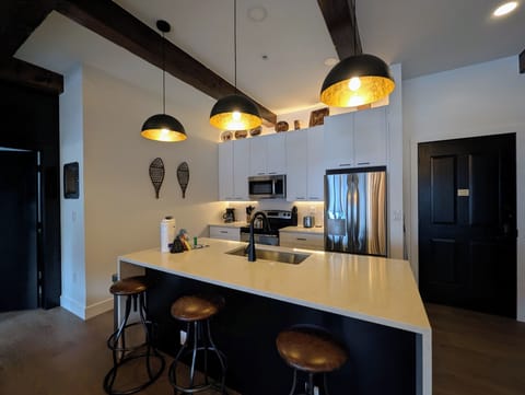 Your gourmet kitchen awaits with sleek appliances, warm pendant lighting, and a spacious island perfect for entertaining