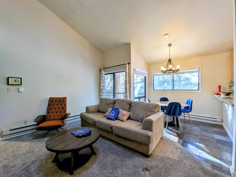 Settle into your cozy open-concept living space with plush seating and warm natural light streaming through large windows.